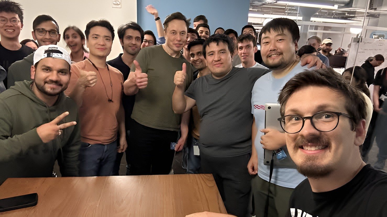 X employees, mostly men, pose with their leader Elon Musk